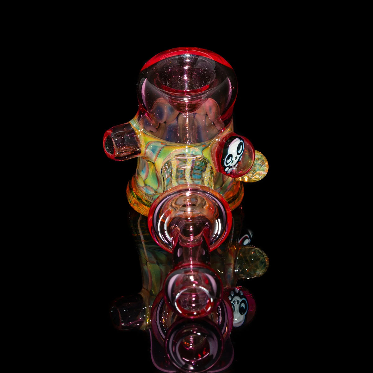 Colorful heady glass dab rig with bear shape and skull accent on black background