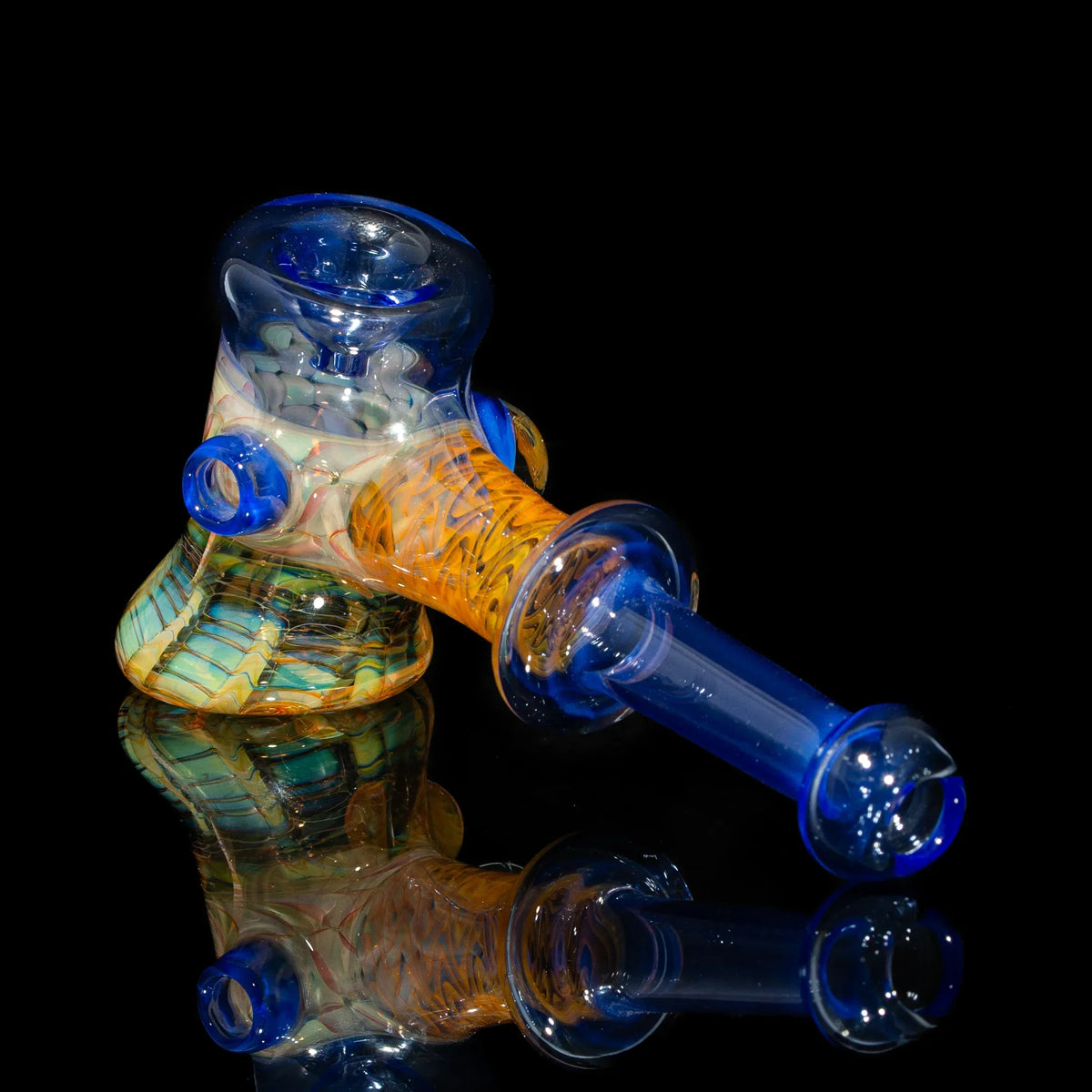 Colorful hand-blown glass pipe with blue, orange, and green accents on black background