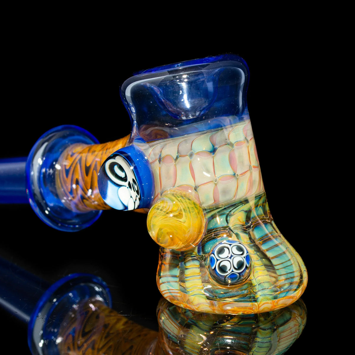 Colorful heady glass hand pipe with intricate patterns and decorative marbles on black background