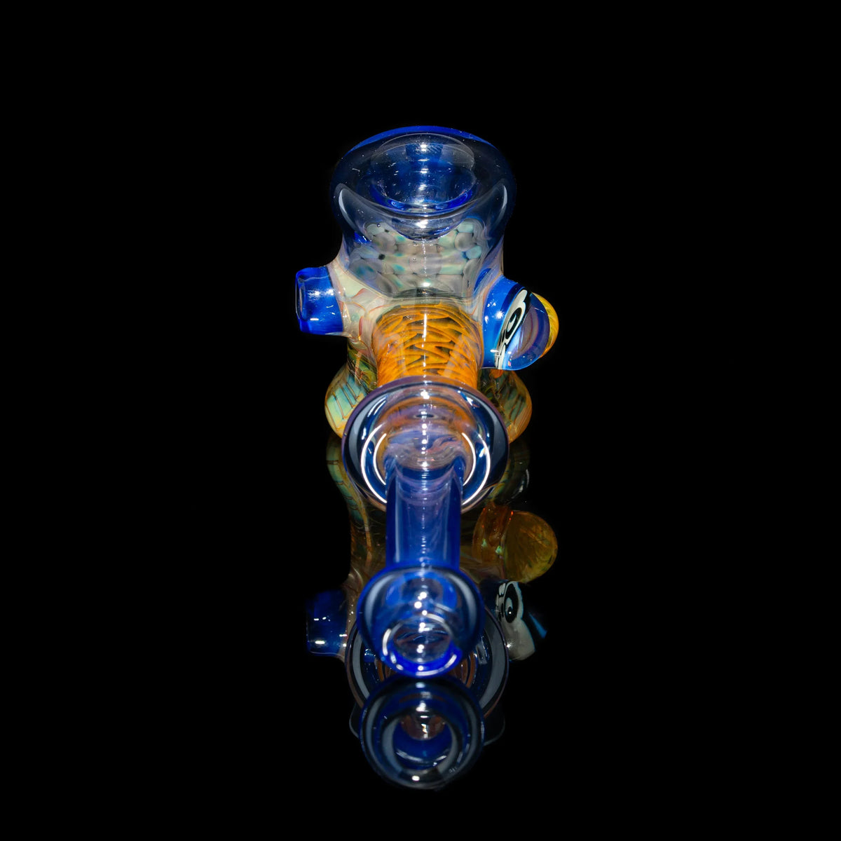Colorful heady glass hand pipe with blue and orange accents on a black reflective surface
