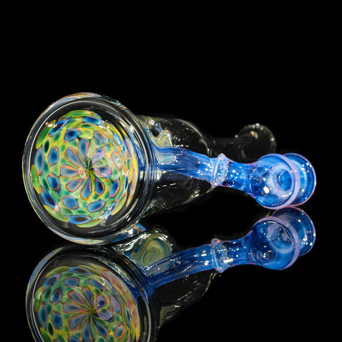 Hand-blown glass pipe with colorful floral pattern, blue handle, and black reflective background