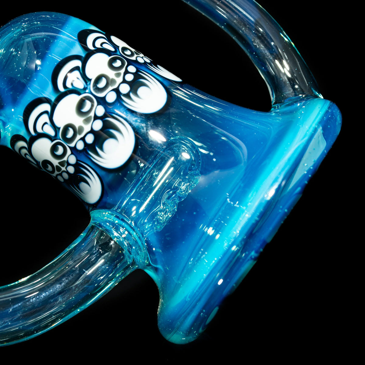 Blue glass water pipe with artistic bear face decals and clear handles on black background