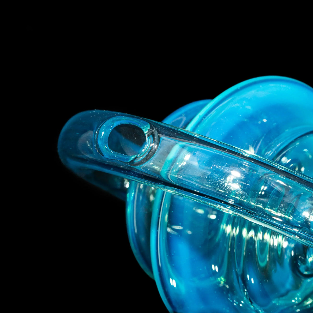 Close-up of transparent blue glass smoking accessory with sleek rounded design