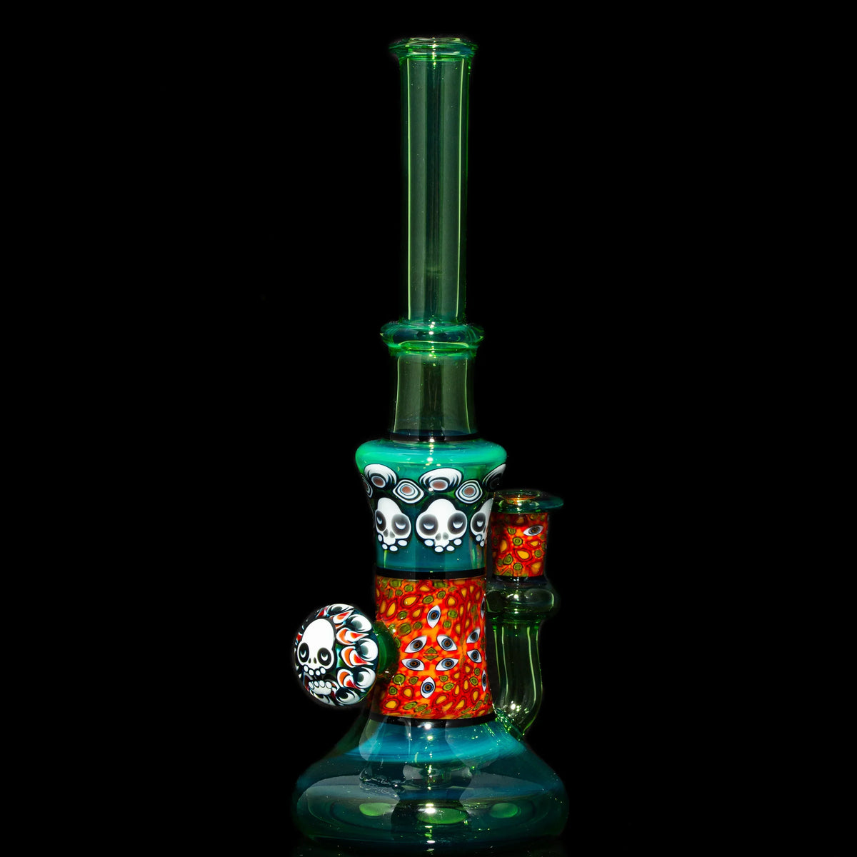 Colorful glass water pipe with skull and eye art accents on a black background