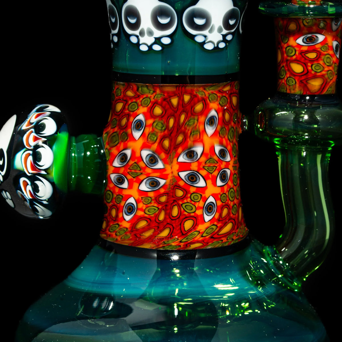 Heady glass water pipe with skull and eye patterns, vibrant colors, unique smoke shop art