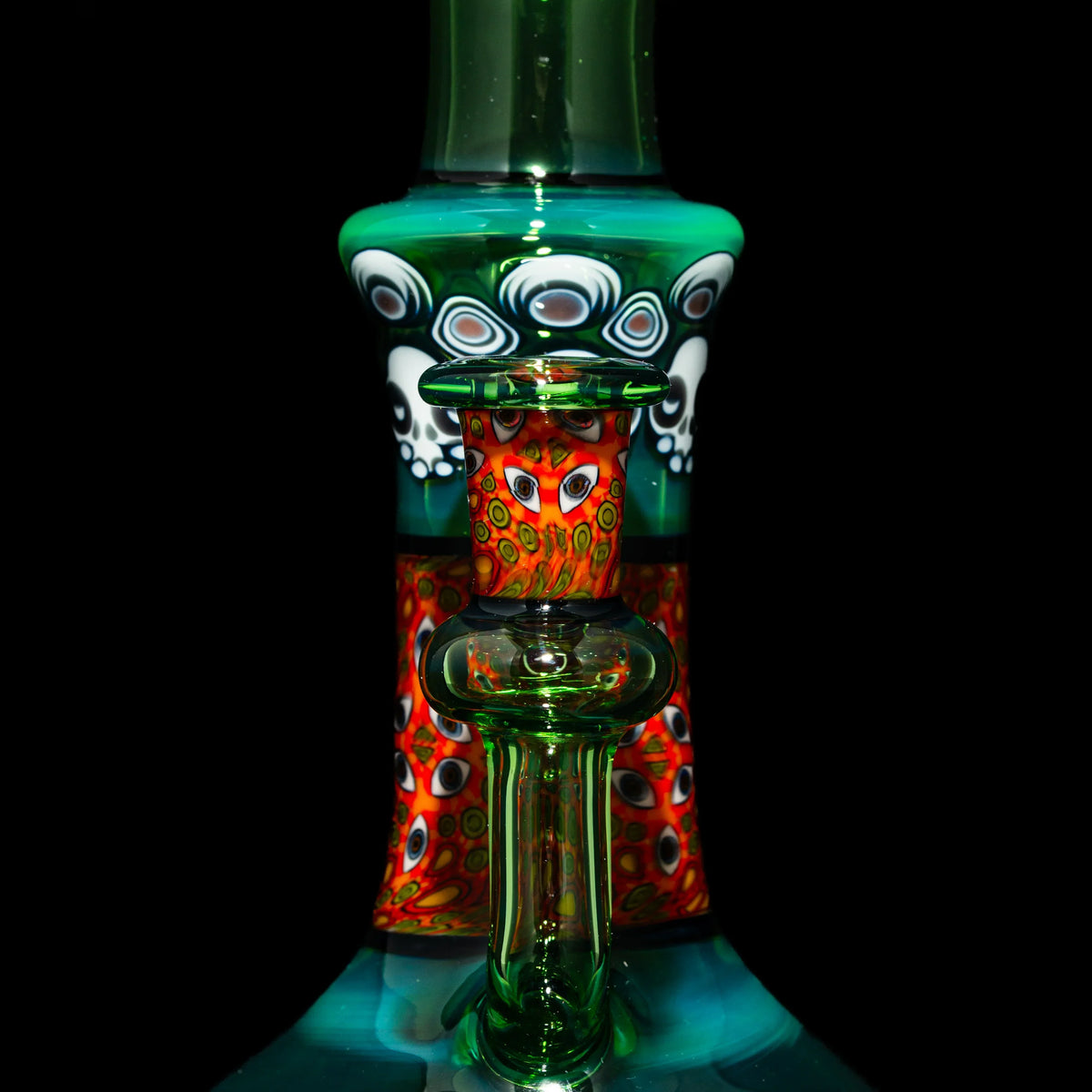 Heady glass water pipe with vibrant red, green, and patterned artwork, close-up view