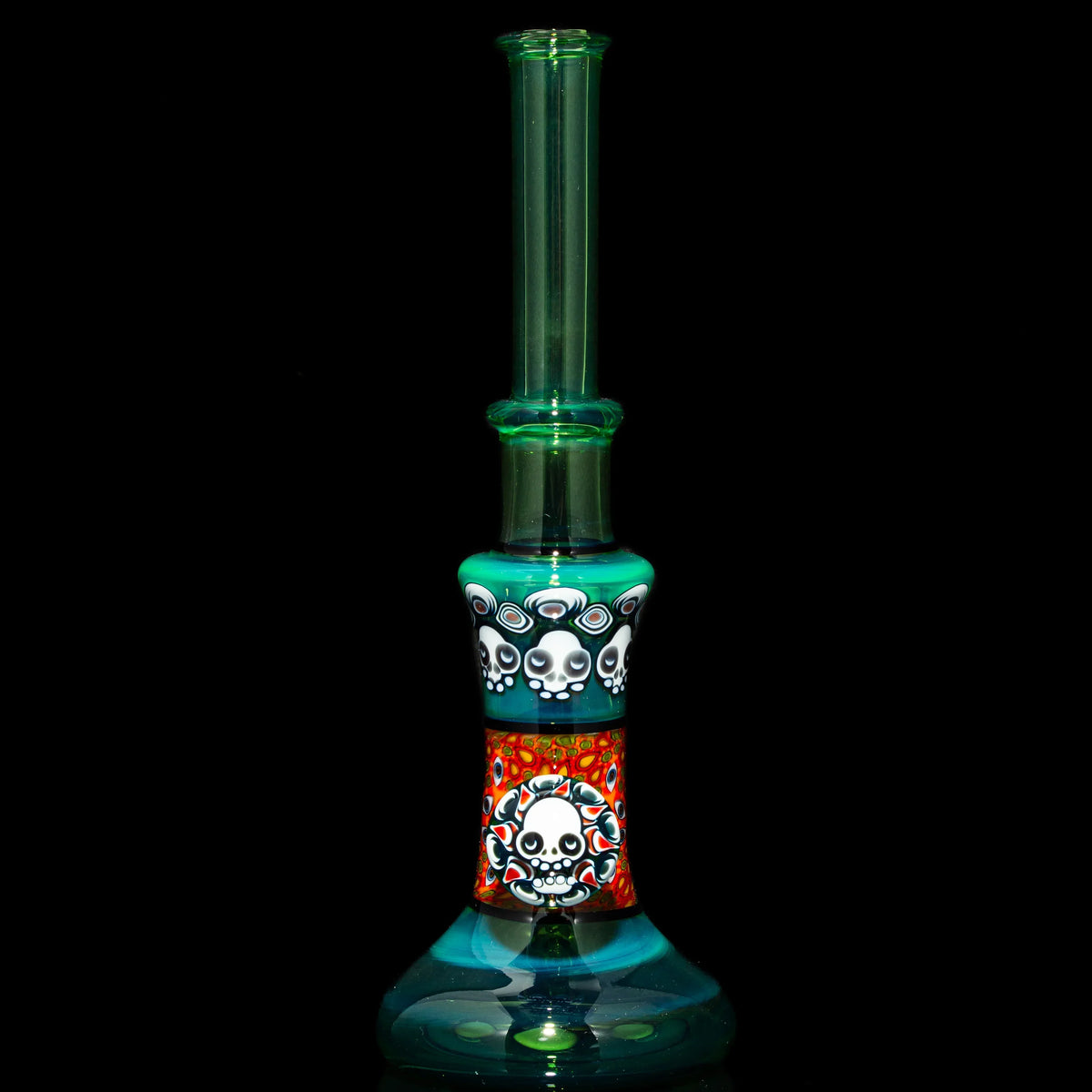 Heady glass water pipe with colorful skull designs and turquoise accents on black background