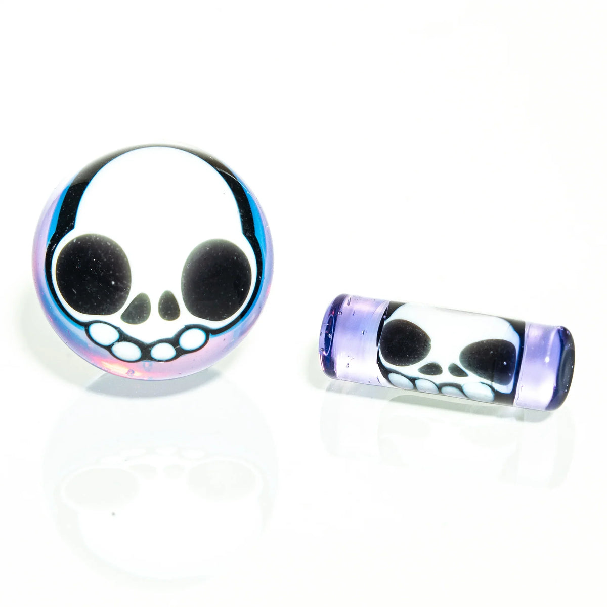 Heady glass carb cap and dab tool with purple accents and skull design on white background