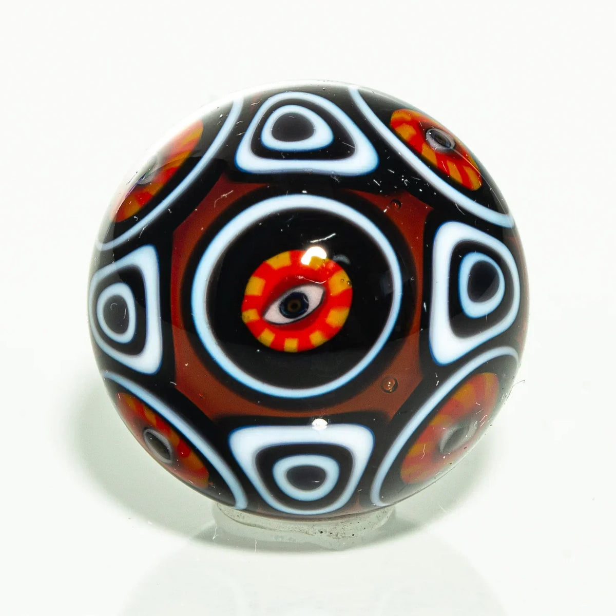 Colorful glass marble with eye and geometric patterns on a white background