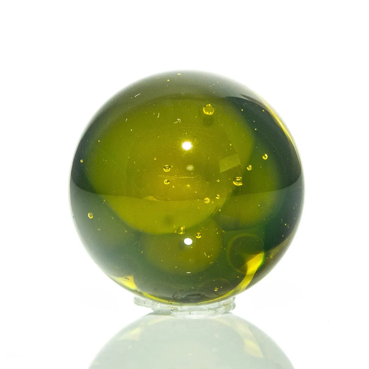 Green glass marble with air bubbles, glass art accessory on white background