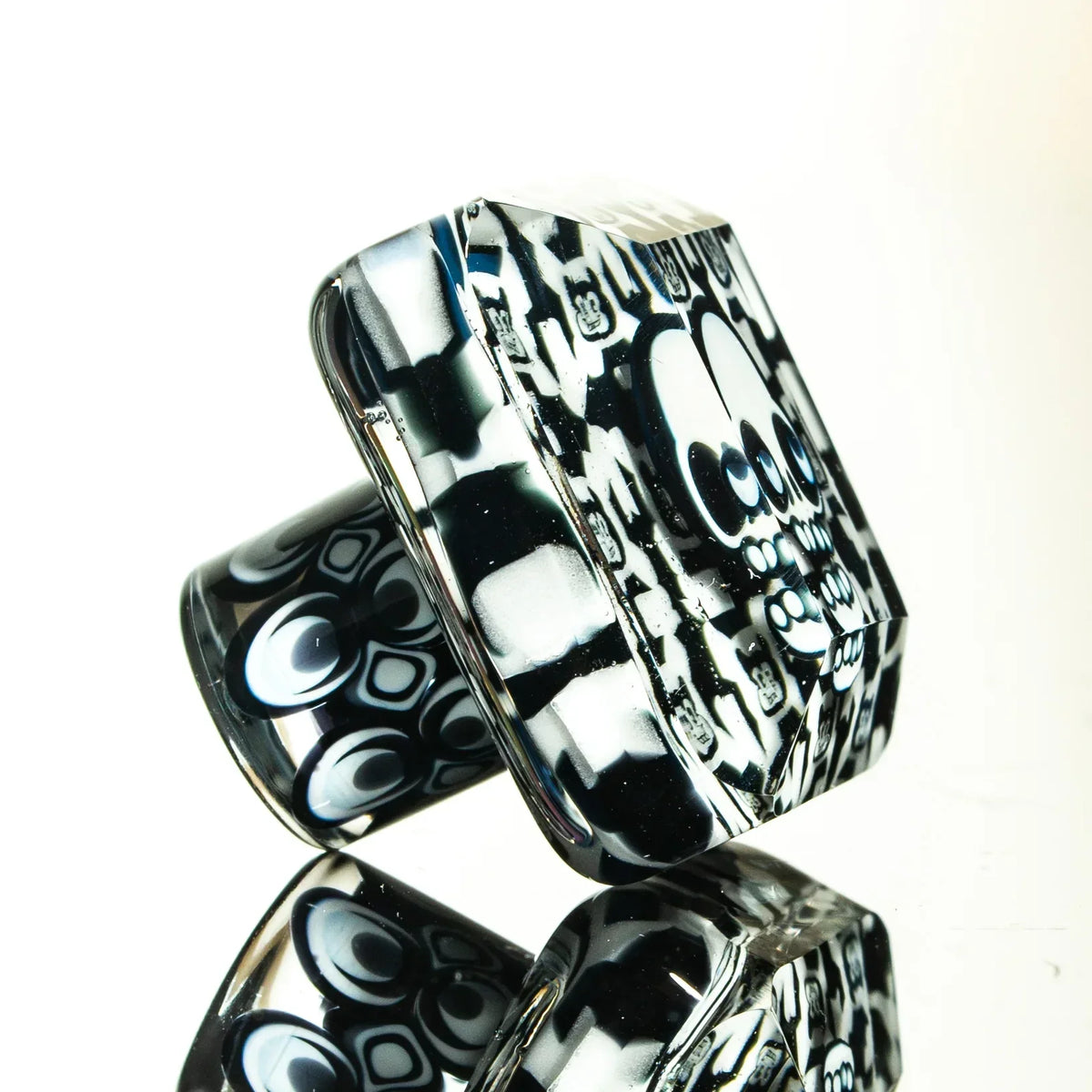 Black and white heady glass art piece with intricate skull and geometric patterns