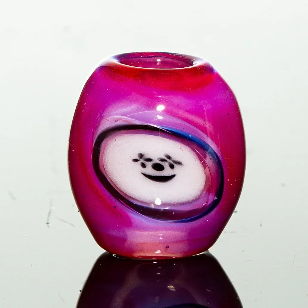 Pink glass bead with a smiling bear face design for glass art and smoking accessories