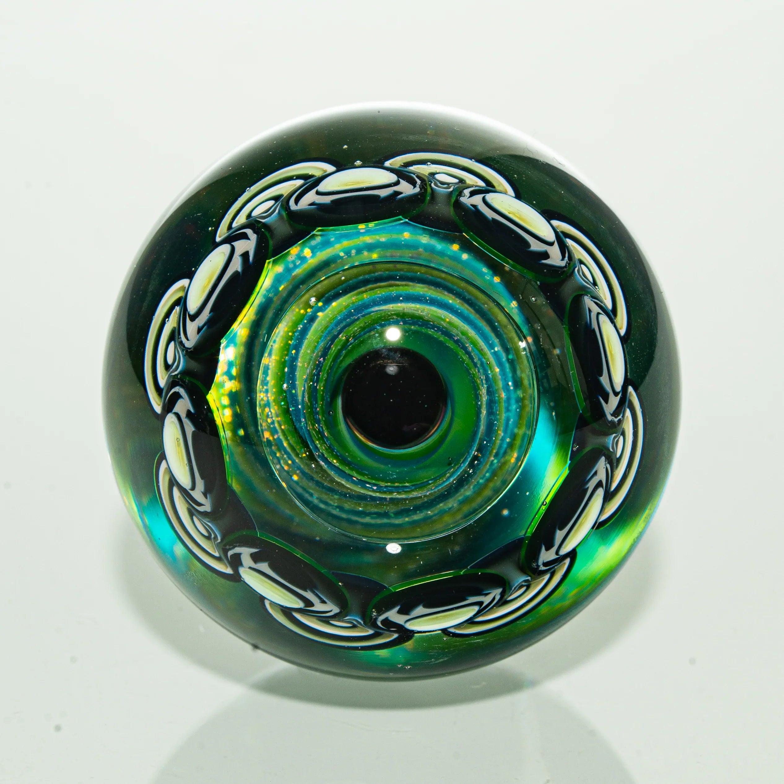Colorful artisan glass marble with black and white chain design and iridescent center