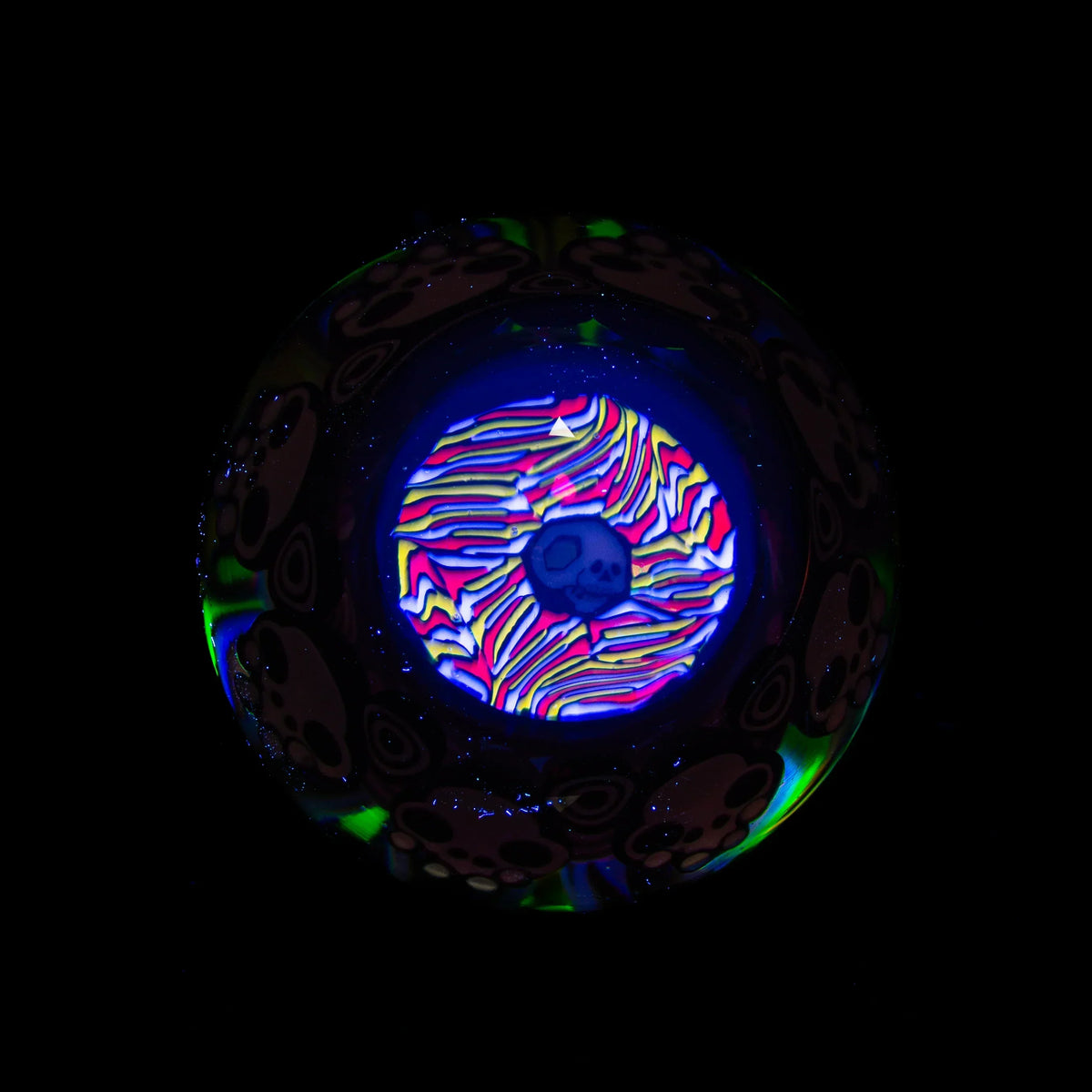 UV reactive glass marble with psychedelic skull design and vibrant neon colors