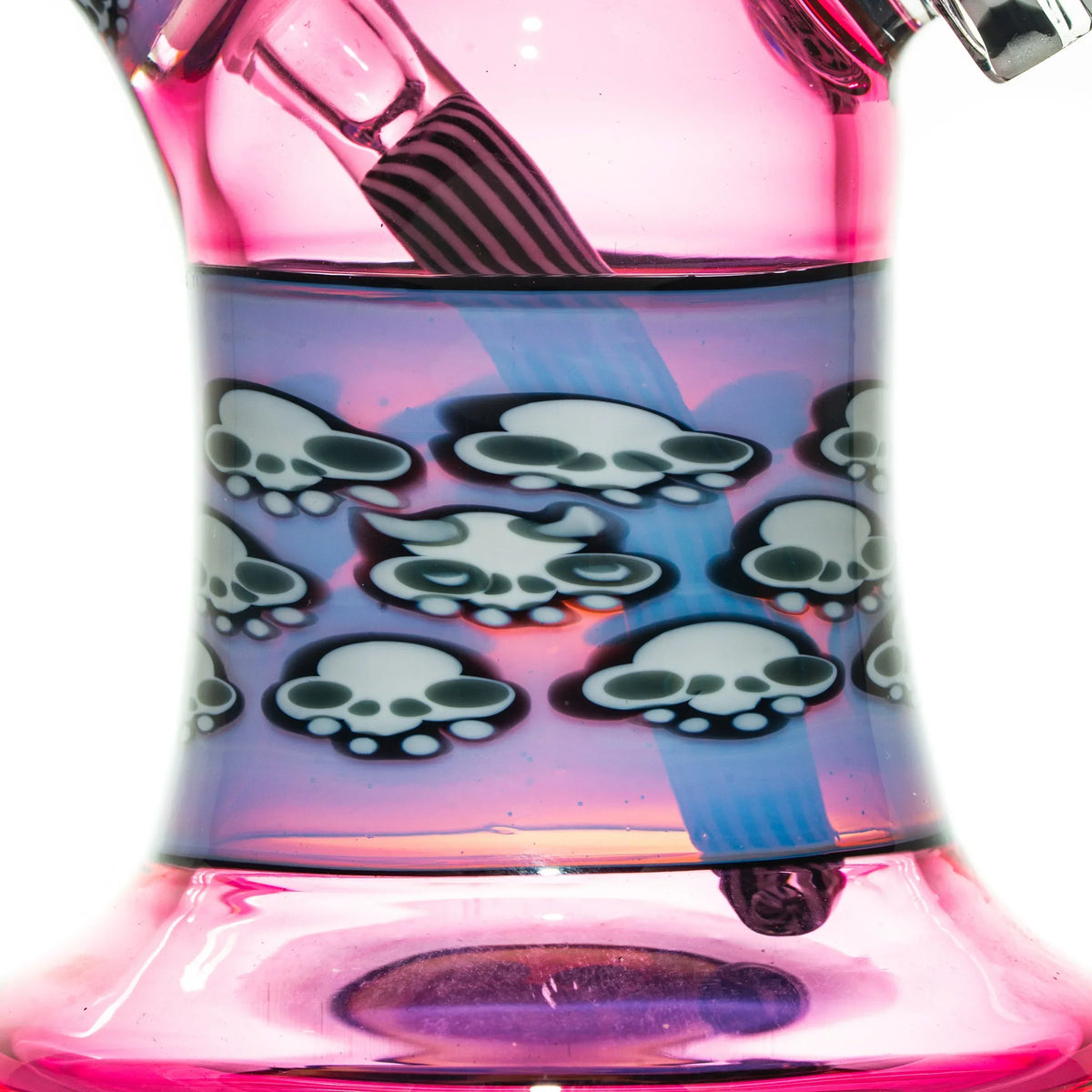 Pink and purple glass water pipe base with skull designs and striped glass downstem