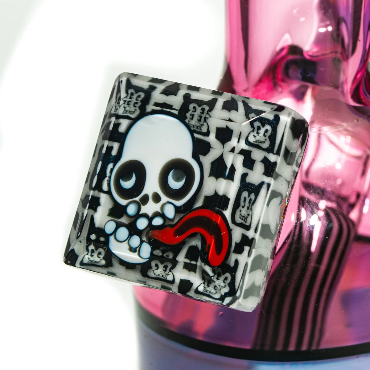 Close-up of a colorful glass bong with a skull motif and red accent on the neck