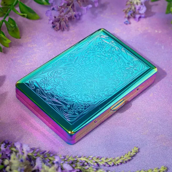 Iridescent metal stash box with engraved floral butterfly design on purple background
