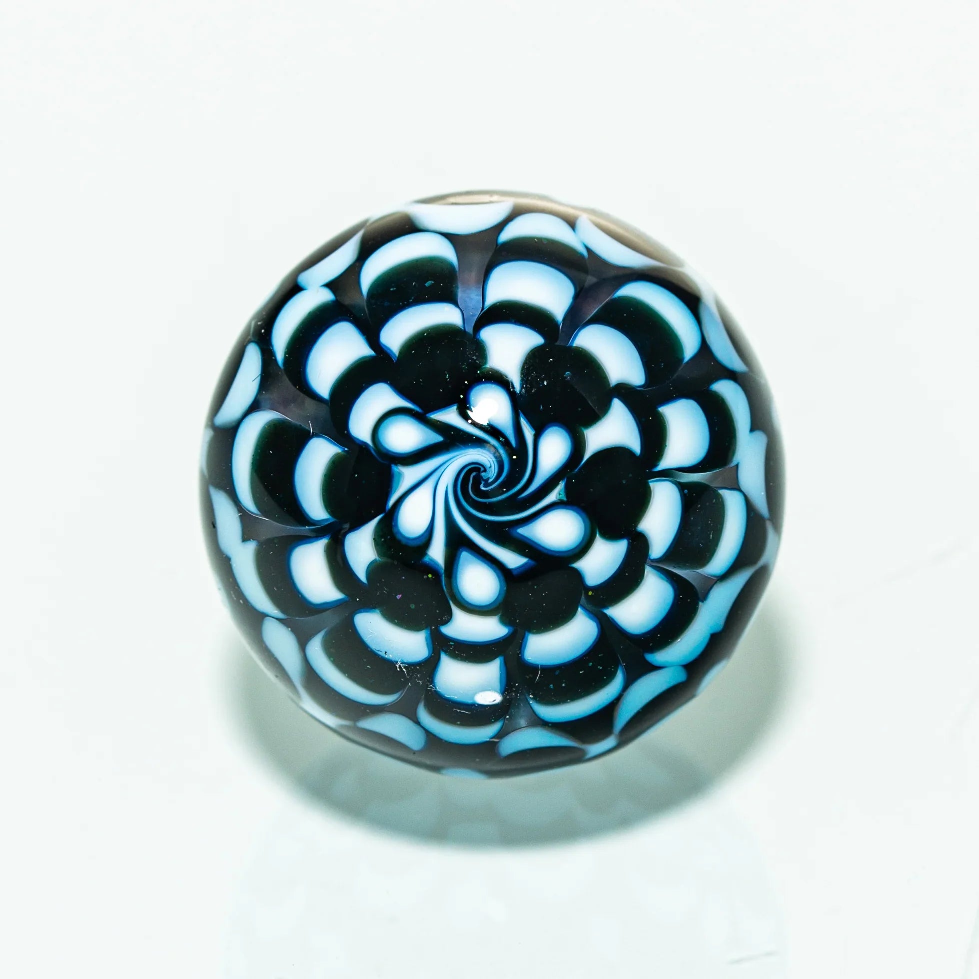 Intricate glass marble with blue and white spiral pattern, heady glass art accessory