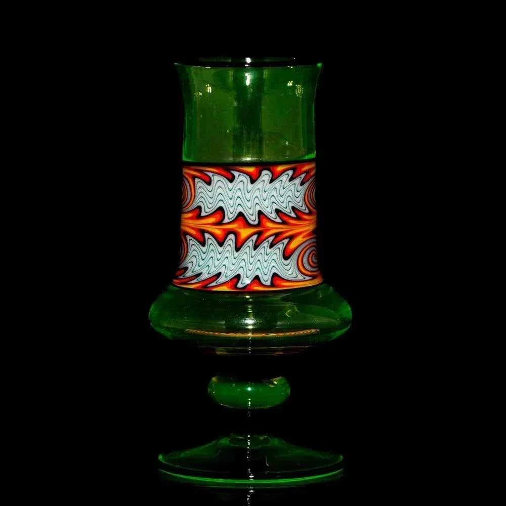 Green glass smoking pipe with intricate red, orange, and white swirl pattern on black background
