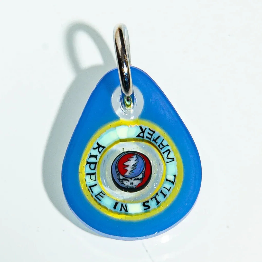 Blue glass keychain with Grateful Dead skull logo and text 'RIPPLE IN STILL WATER'