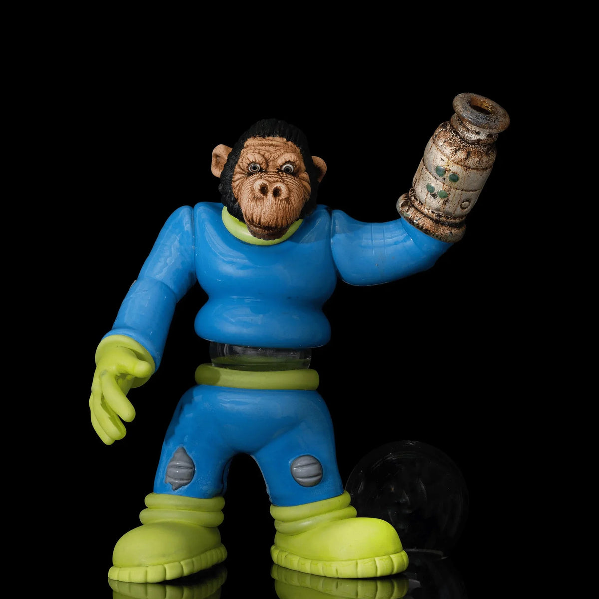Colorful glass figure of a monkey in blue suit holding accessory, black background