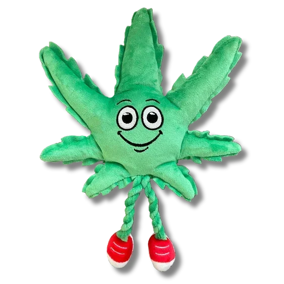 Plush green leaf toy with smiling face, braided legs, and red shoes on white background.
