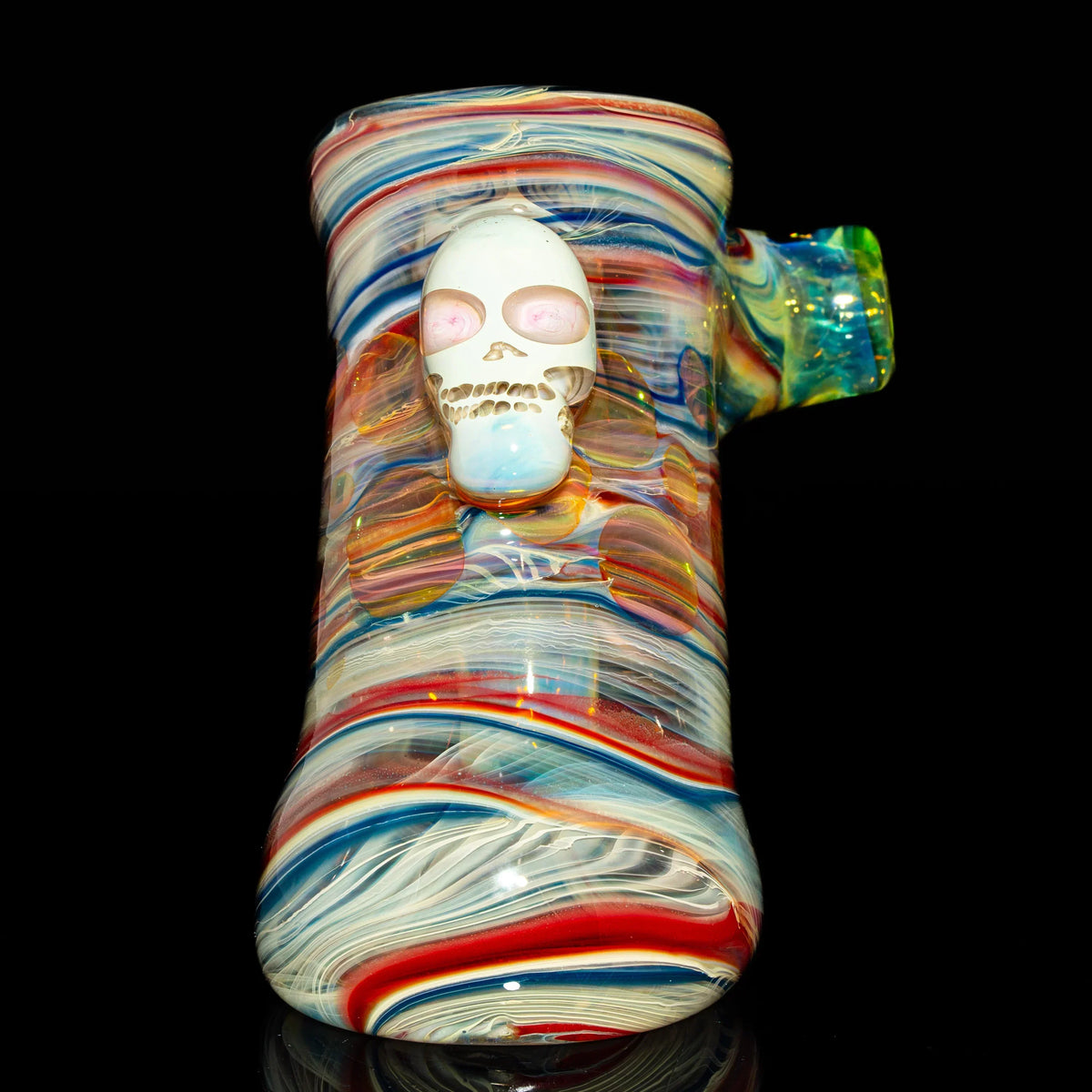 Colorful heady glass pipe with swirling patterns and a skull detail on a black background