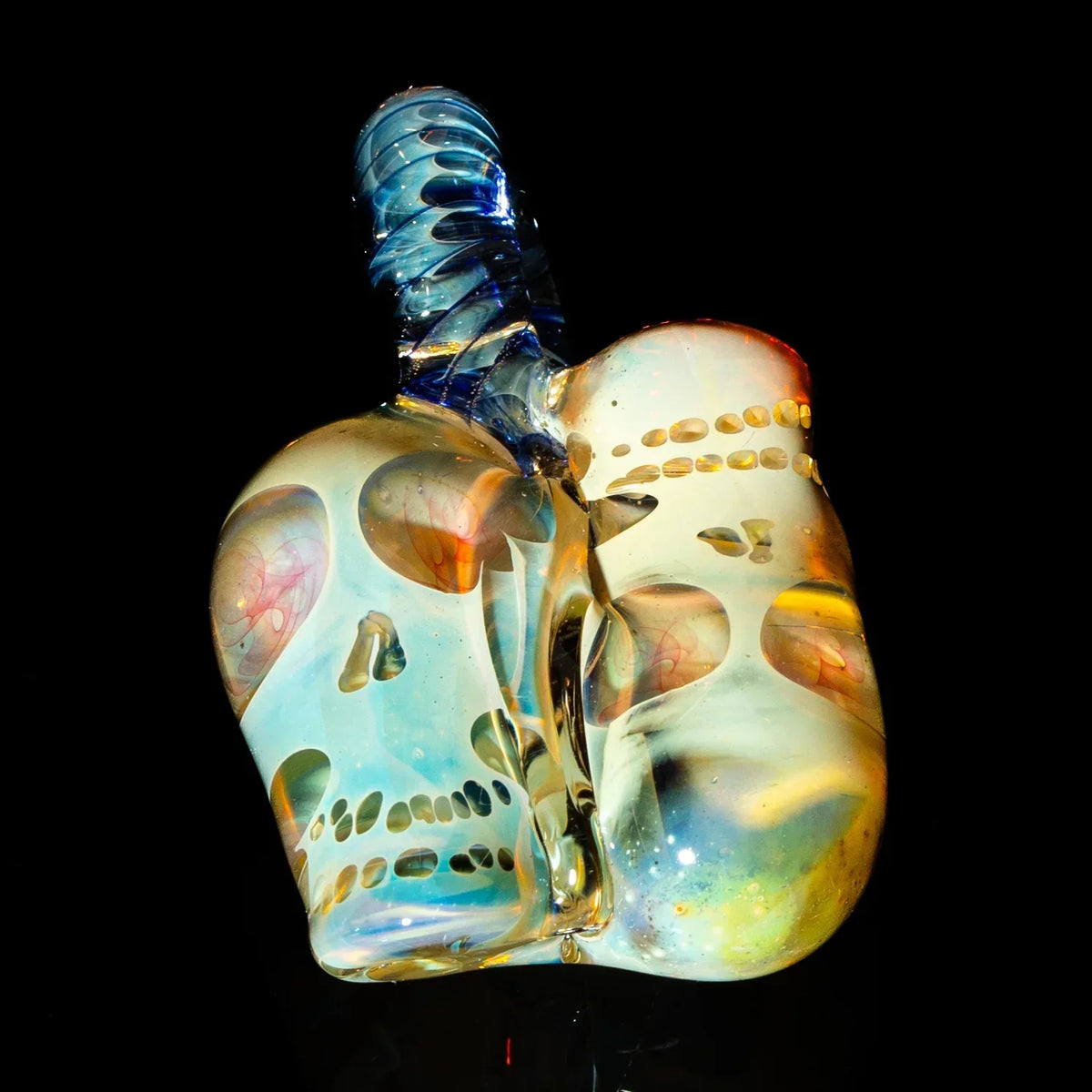 Hand-blown glass pipe featuring dual skull designs with iridescent colors on black background