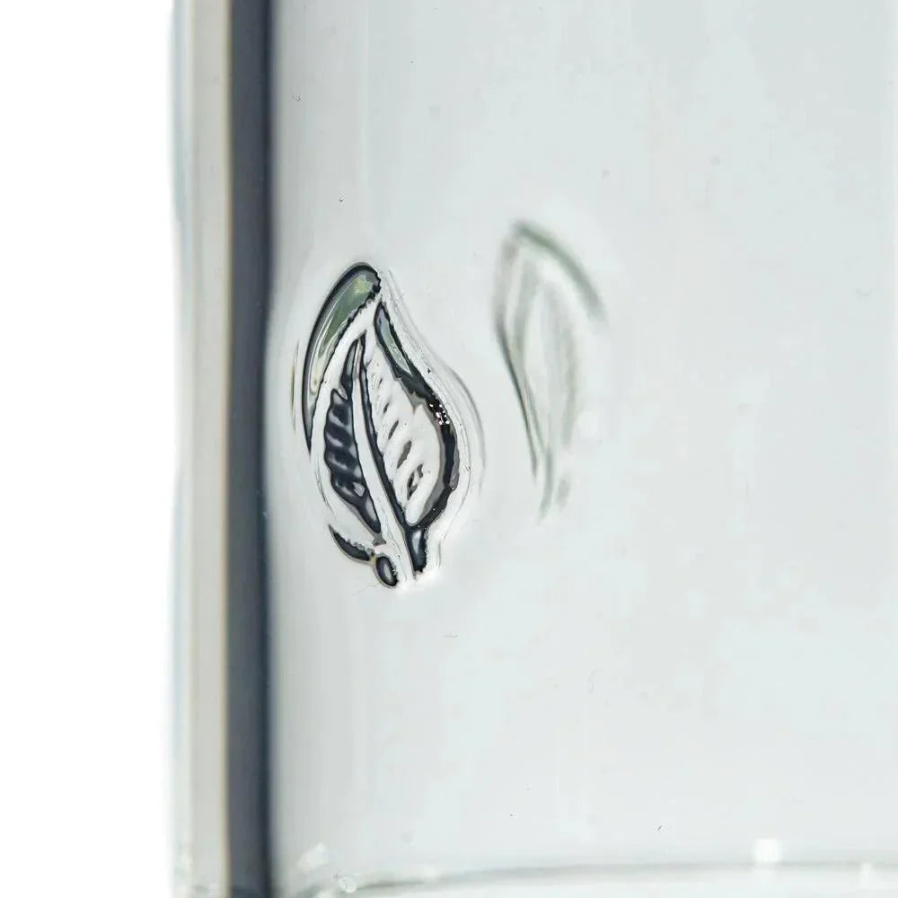 Close-up of clear glass with embossed leaf design, smoking accessory detail