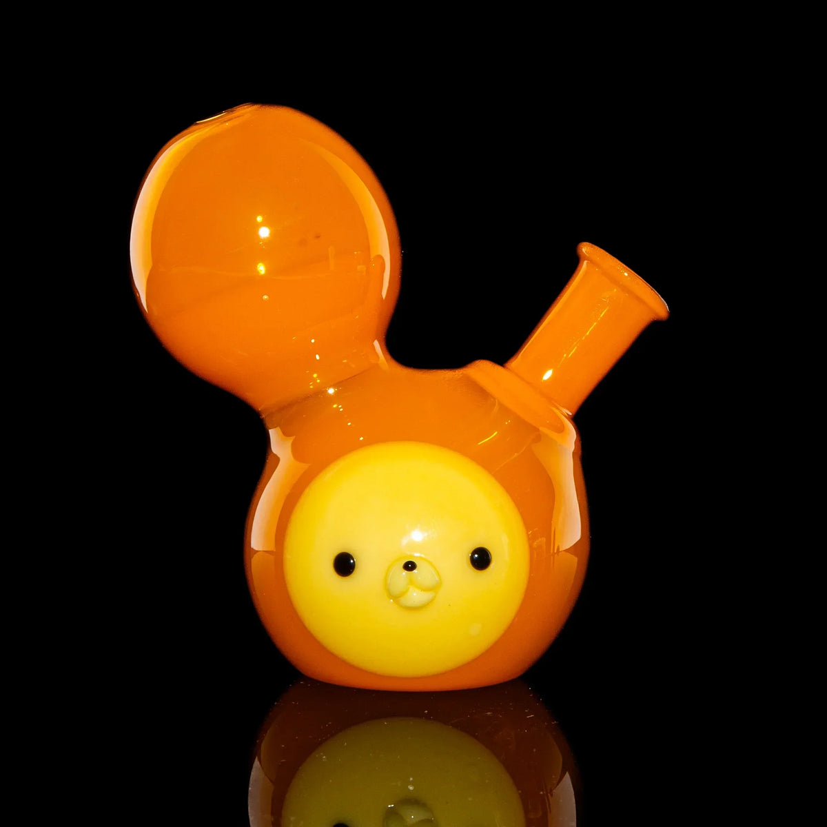Orange glass water pipe with a cute animal face design on a black background