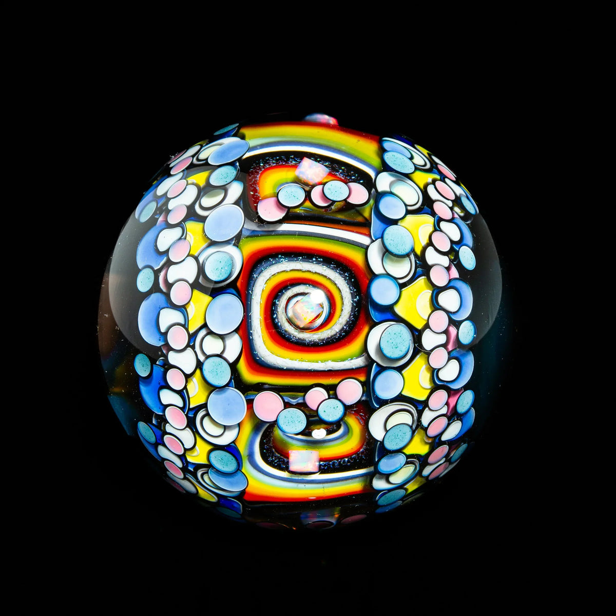 Colorful heady glass marble with rainbow spiral and dot patterns on a black background