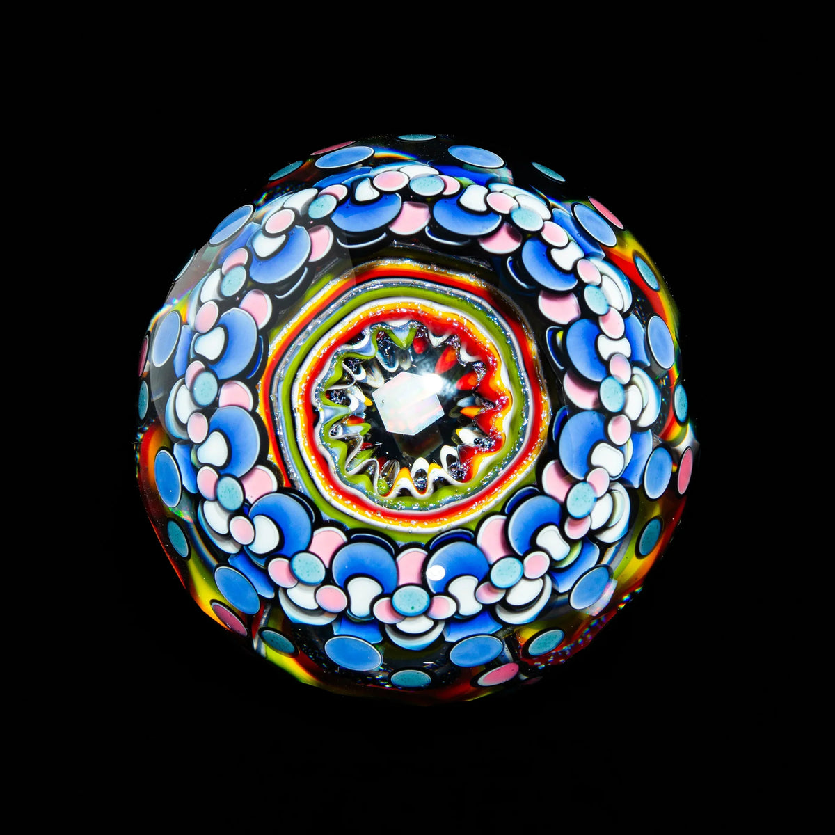 Intricate hand-blown glass marble with colorful floral patterns on black background