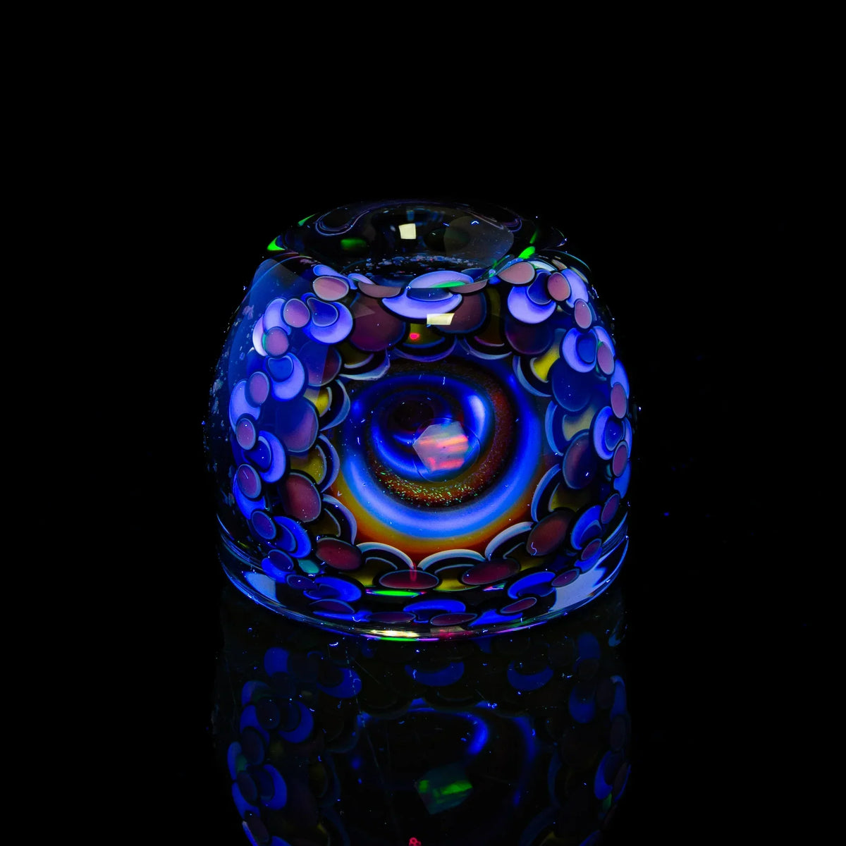 Colorful heady glass artwork with vibrant patterns on a reflective black background