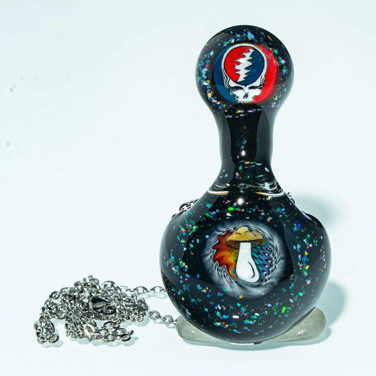 Black glass pendant with colorful mushroom and skull designs, chain included