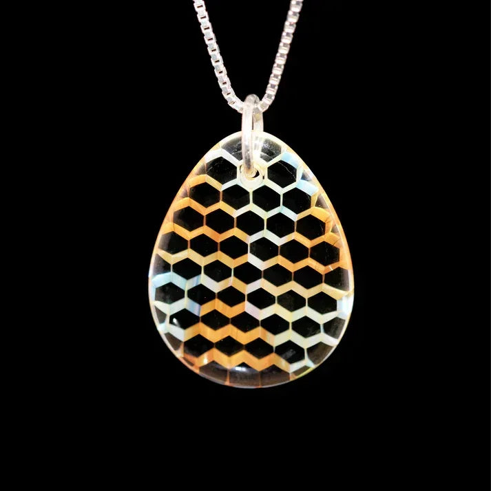 Teardrop glass pendant with geometric honeycomb pattern on a silver chain