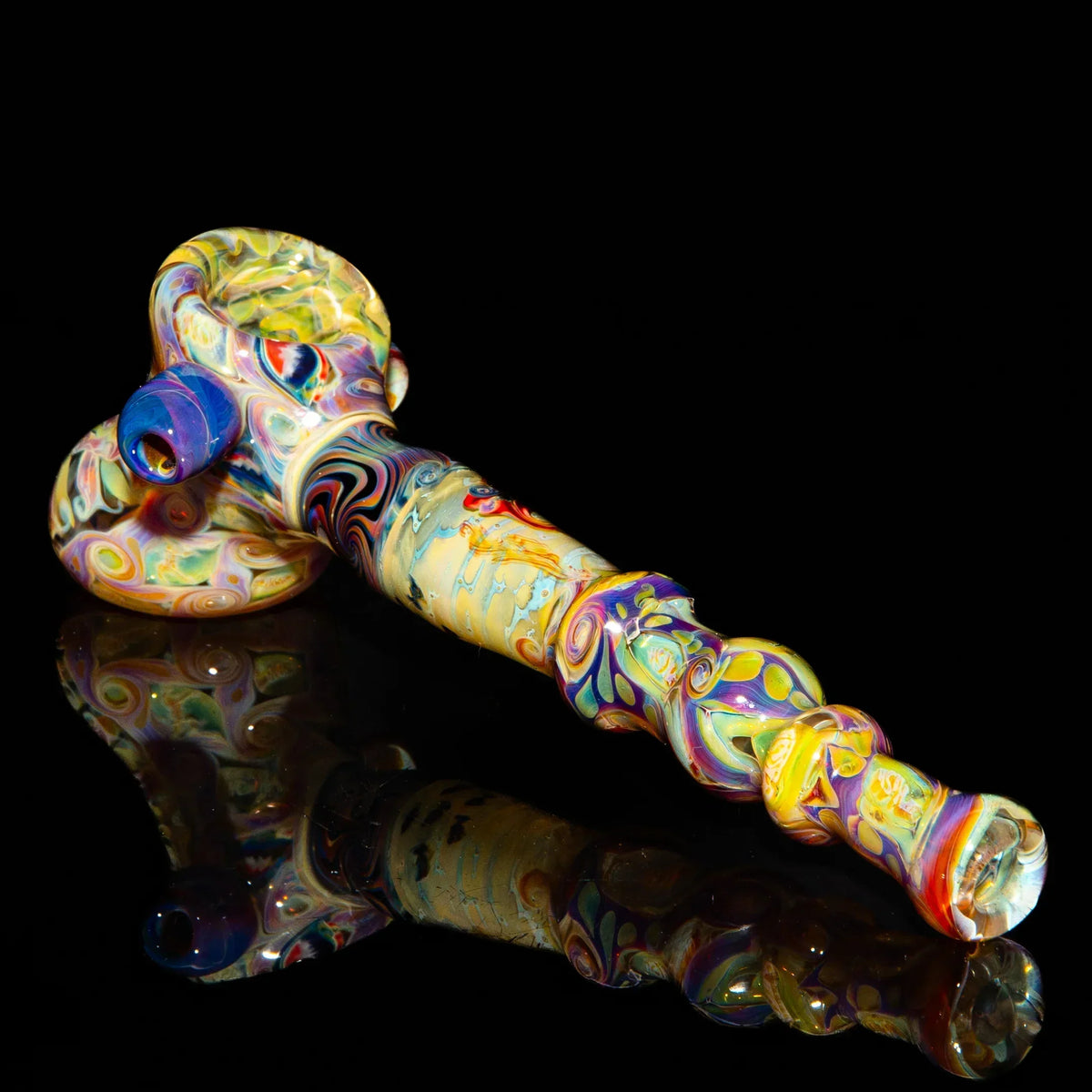 Heady glass hand pipe with vibrant, multicolor swirling patterns on a black background.