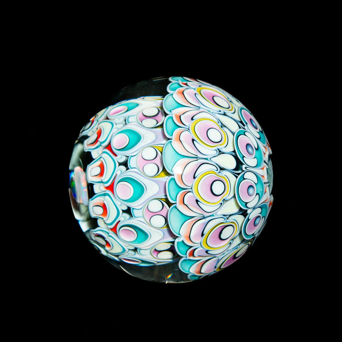Colorful heady glass marble with intricate pastel patterns on a black background