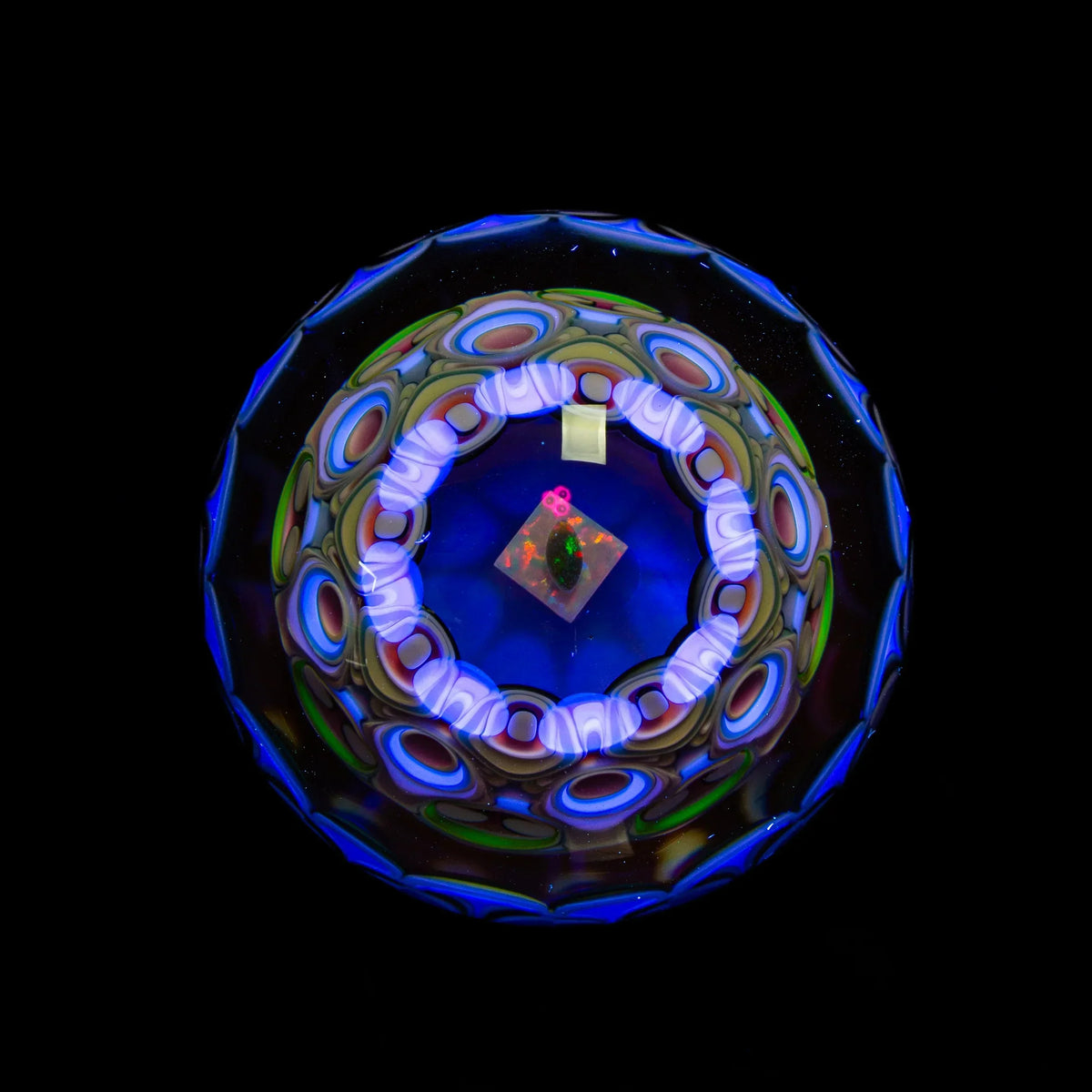 Colorful heady glass art marble with intricate patterns and UV-reactive details on black background