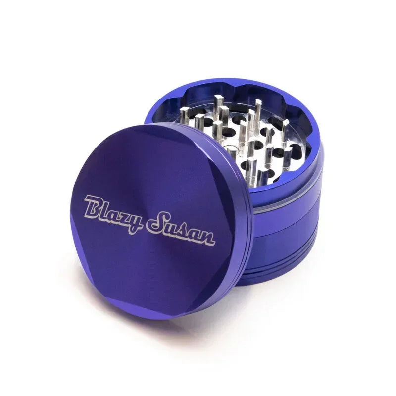 Purple metal herb grinder with Blazy Susan logo, open to show sharp grinding teeth.