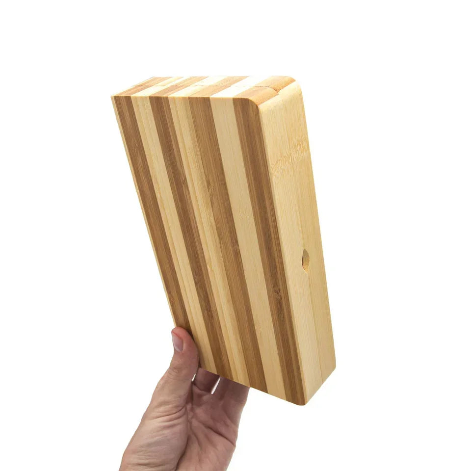 Hand holding striped magnetic bamboo rolling tray against a white background
