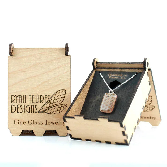 Handmade glass pendant necklace in a wooden display box engraved with Ryan Teures Designs