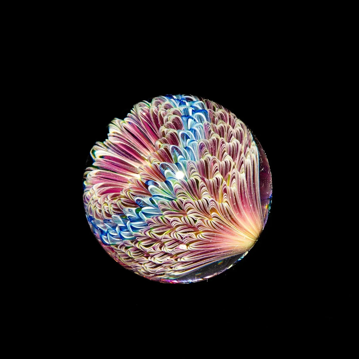 Colorful heady glass marble with UV reactive flower pattern on black background