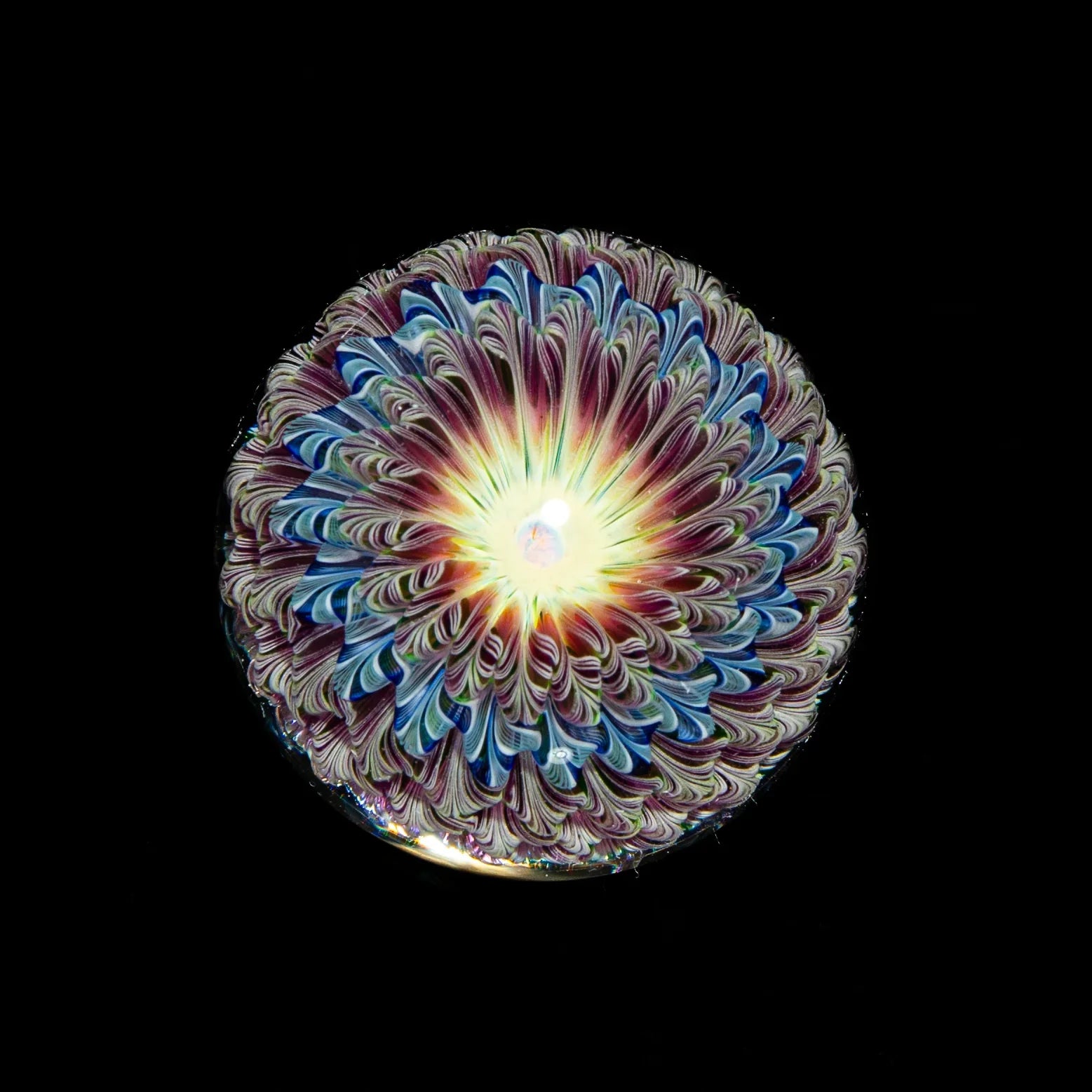 UV reactive glass art flower marble with intricate swirl patterns, black background