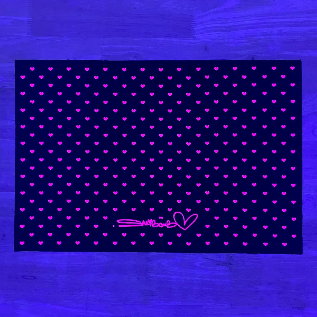 Purple and pink glass mat with heart pattern and Sakibomb signature, neon light glow