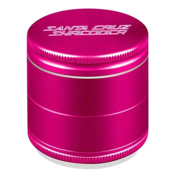 Medium pink metal herb grinder with textured edges and engraved logo on lid.