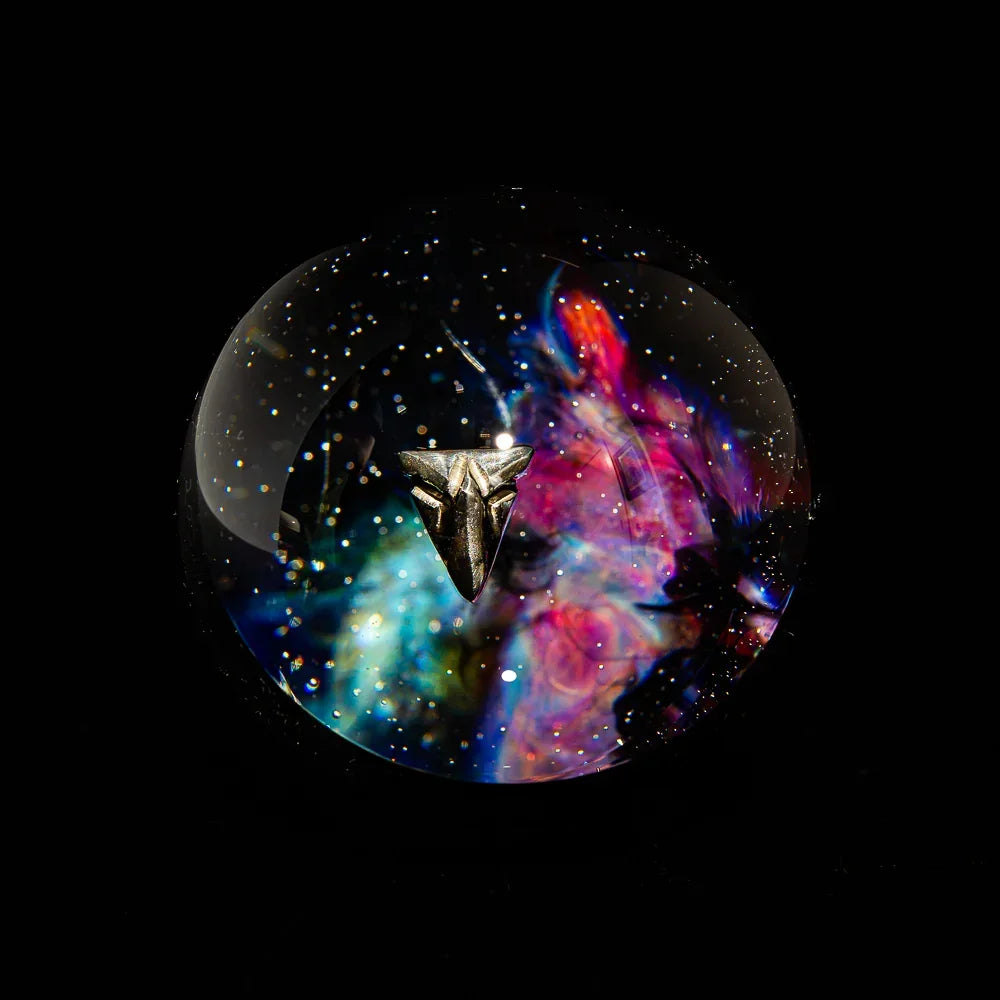 Colorful glass marble with galaxy design and metallic accent on black background