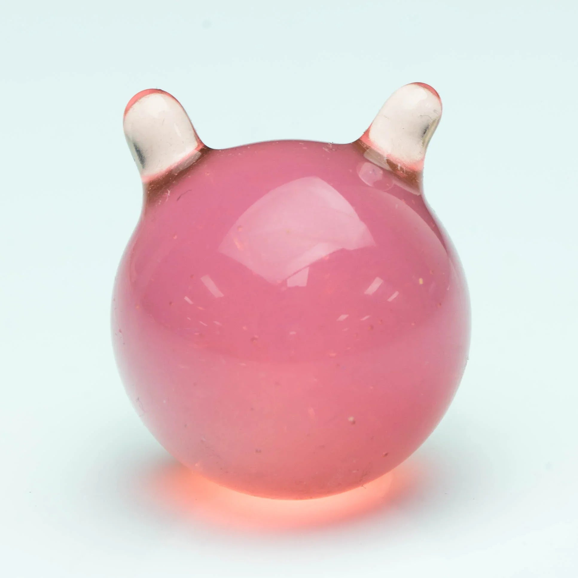 Pink glass carb cap with two clear horn-like handles, photographed on a white background