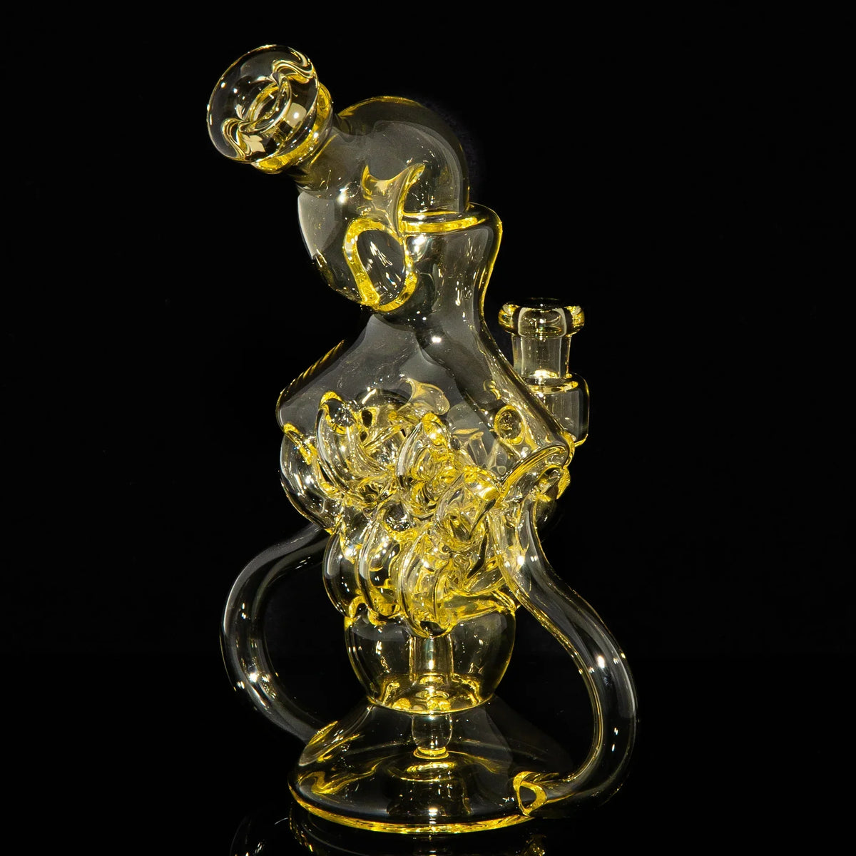 Intricate clear and yellow glass water pipe with abstract artistic design on black background