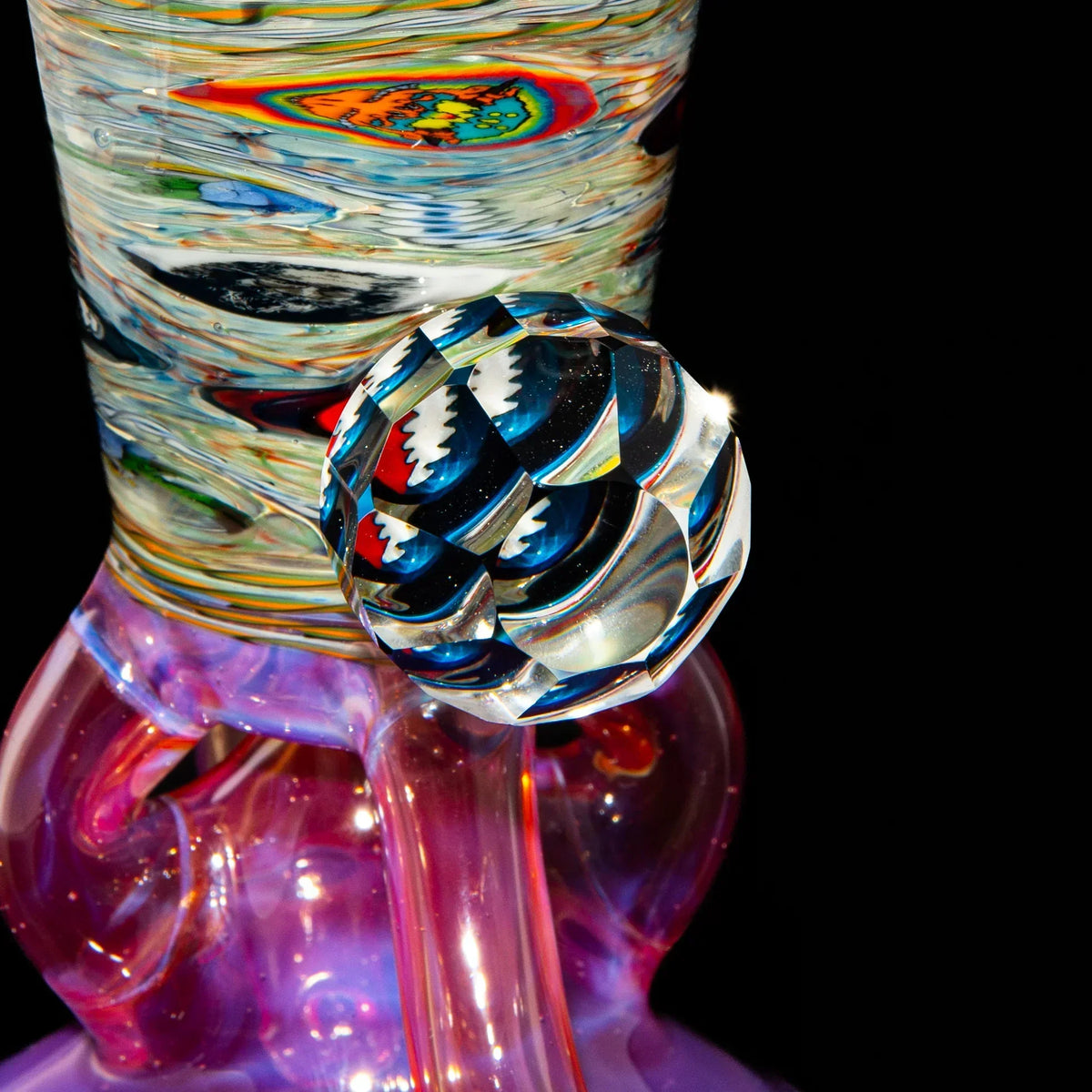 Close-up of artistic heady glass water pipe with colorful patterns and faceted accent