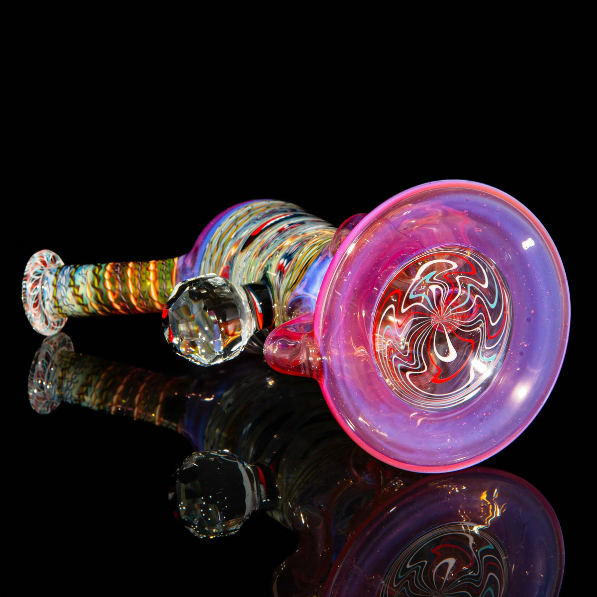 Colorful heady glass pipe with intricate patterns and a crystal accent on black background